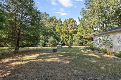a view of backyard with outdoor seating and trees