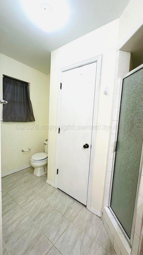 6820 Rochelle Lane Amarillo, TX 79109 - Photo 12 of 18 a bathroom with a toilet and a shower