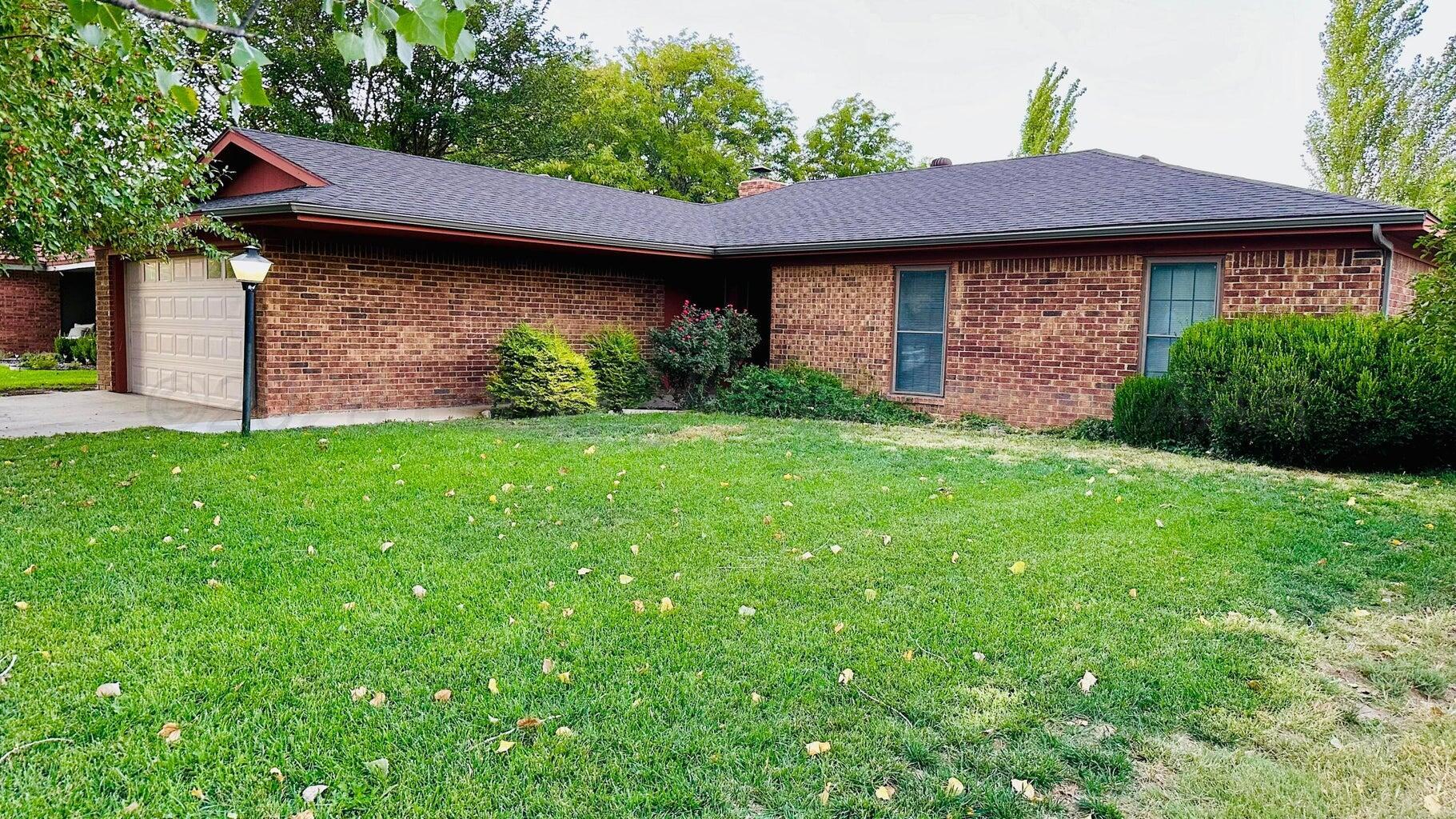 6820 Rochelle Lane Amarillo, TX 79109 - Photo 3 of 18 a view of a backyard with a barbeque grill and a small yard