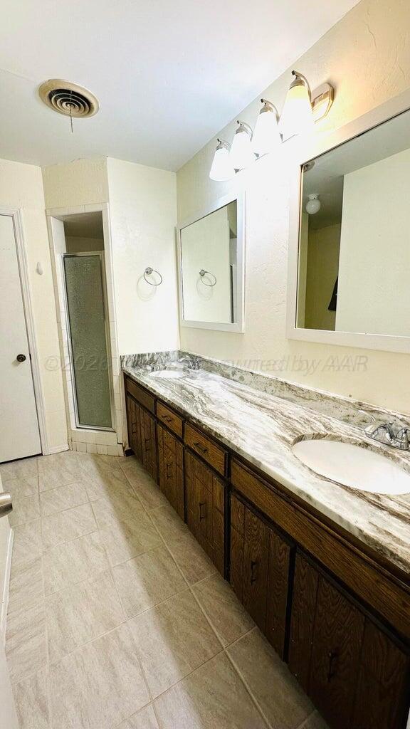 6820 Rochelle Lane Amarillo, TX 79109 - Photo 10 of 18 a spacious bathroom with a granite countertop sink and a mirror