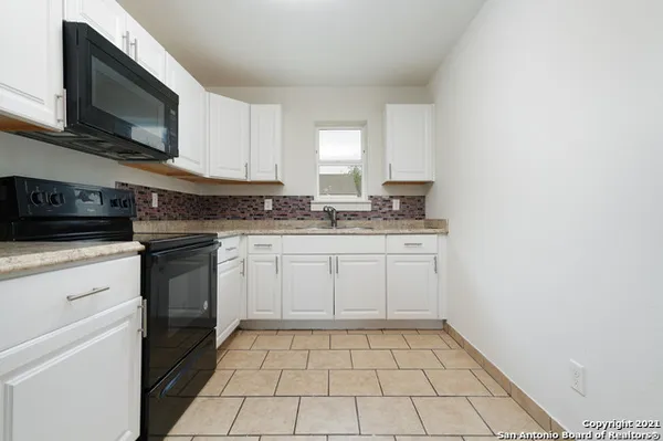 a kitchen with a sink stove and cabinets