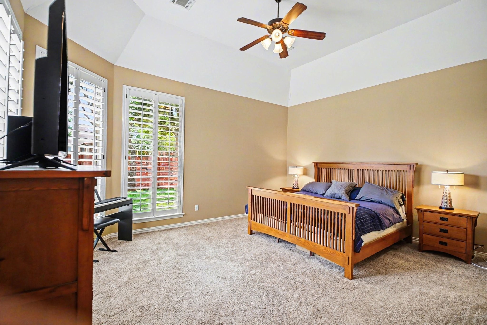 8210 Thunder Ridge Way Missouri City, TX 77459 - Photo 22 of 42 The private primary suite, located off the den, features coffered ceilings and large windows overlooking the backyard, creating a bright and airy retreat.