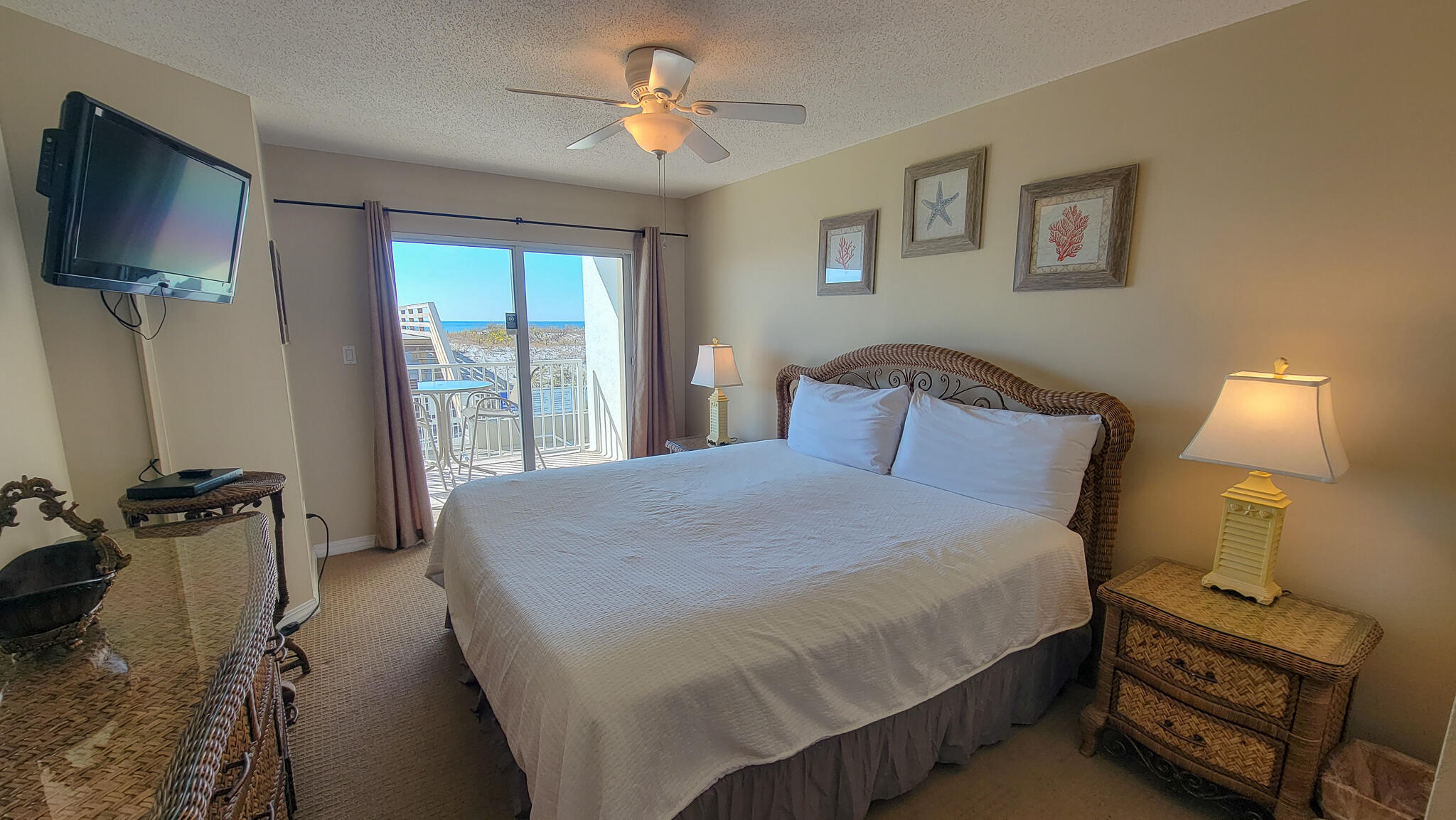 376 Santa Rosa Boulevard, Unit 115 Fort Walton Beach, FL 32548 - Photo 13 of 37 a bedroom with a bed a couch and a flat tv screen on the dresser