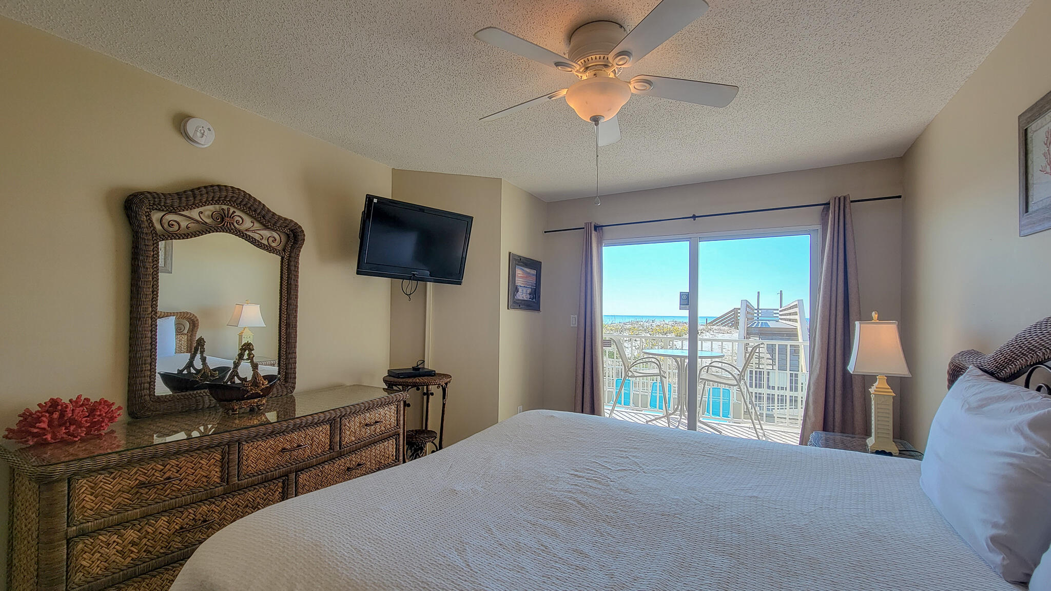376 Santa Rosa Boulevard, Unit 115 Fort Walton Beach, FL 32548 - Photo 14 of 37 a bedroom with a large bed and a flat tv screen on dresser