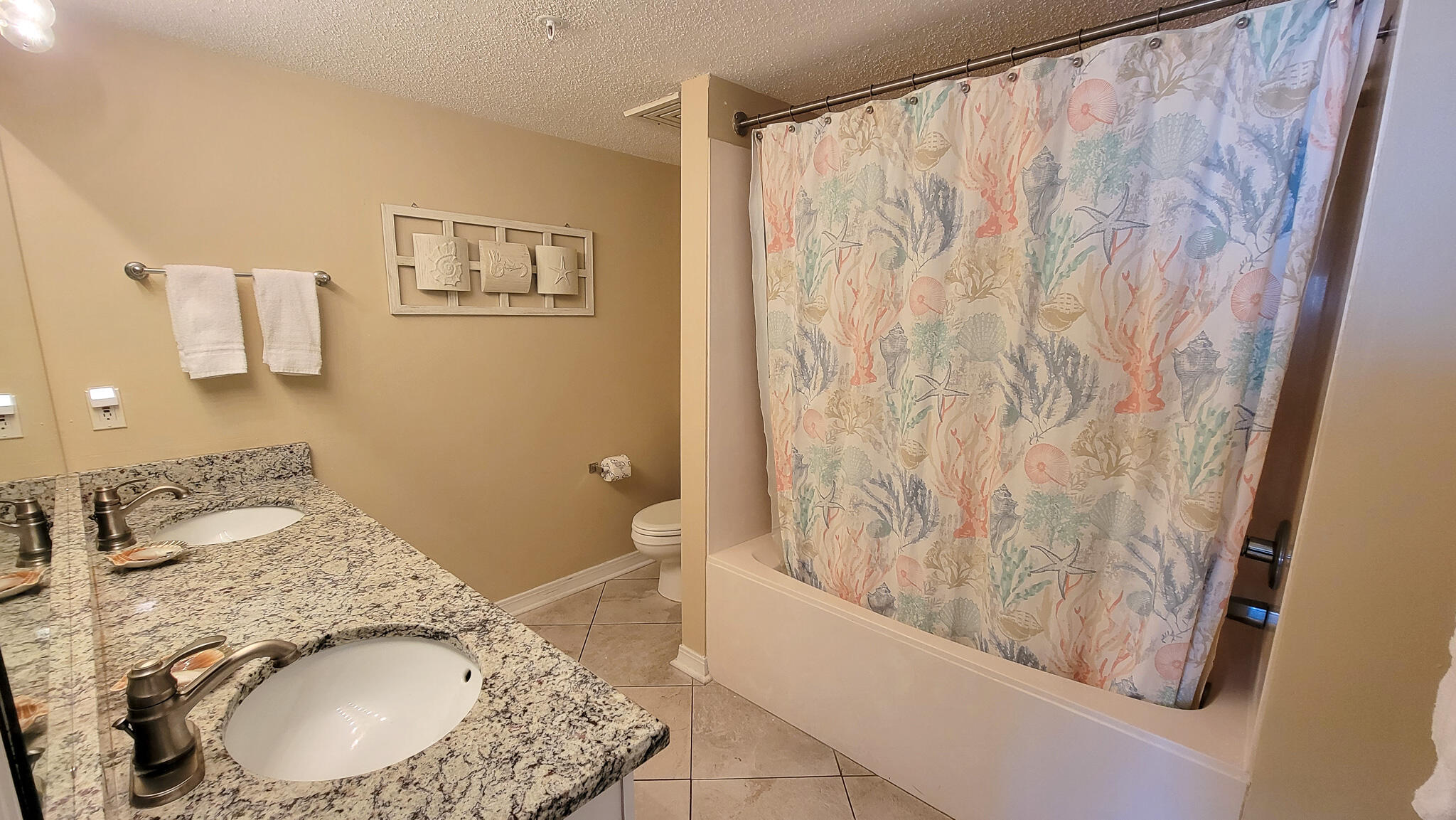 376 Santa Rosa Boulevard, Unit 115 Fort Walton Beach, FL 32548 - Photo 17 of 37 a bathroom with a granite countertop sink a mirror and shower