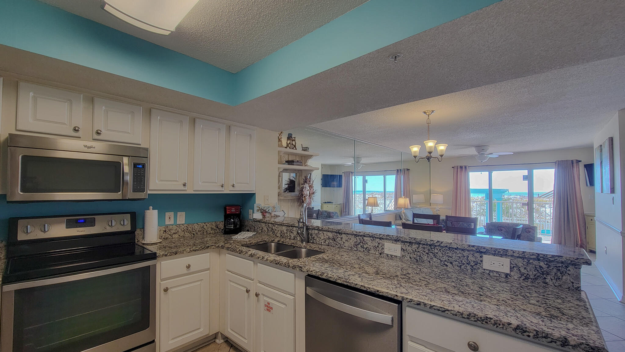 376 Santa Rosa Boulevard, Unit 115 Fort Walton Beach, FL 32548 - Photo 3 of 37 a kitchen with stainless steel appliances granite countertop a stove a sink and a microwave