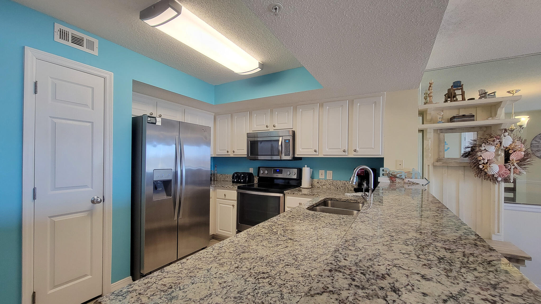 376 Santa Rosa Boulevard, Unit 115 Fort Walton Beach, FL 32548 - Photo 4 of 37 a kitchen with stainless steel appliances granite countertop a refrigerator and a sink
