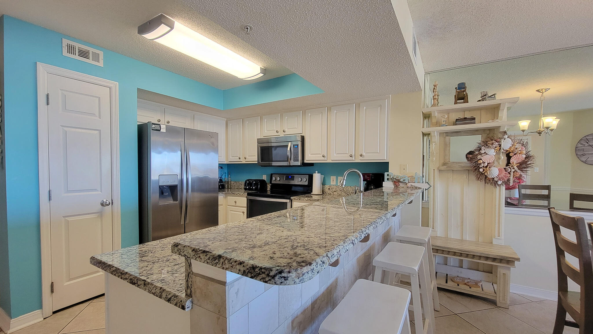 376 Santa Rosa Boulevard, Unit 115 Fort Walton Beach, FL 32548 - Photo 5 of 37 a kitchen with stainless steel appliances granite countertop a sink refrigerator and cabinets