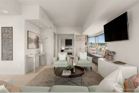 a living room with furniture a flat screen tv and a view of kitchen