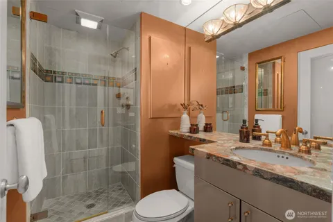 a bathroom with a granite countertop sink toilet and shower