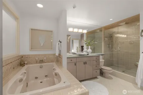 a bathroom with a bathtub shower sink mirror and toilet