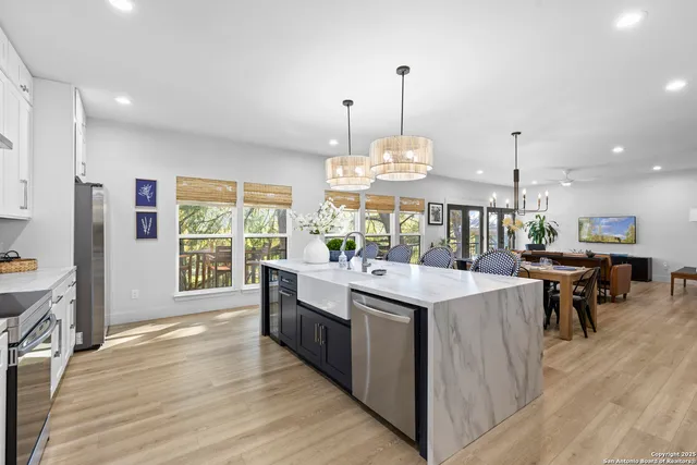 a view of a kitchen with kitchen island a stove a wooden floor and a large window