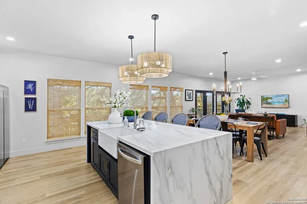 a view of a dining room and livingroom with furniture wooden floor a chandelier