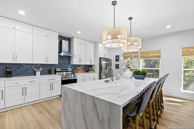 a large kitchen with kitchen island a large island in it