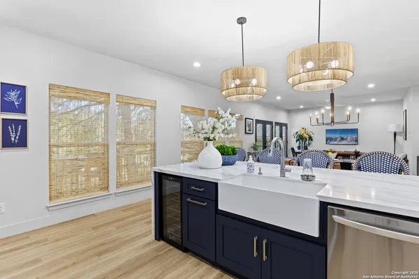 a view of a kitchen counter space a sink wooden floor and a chandelier