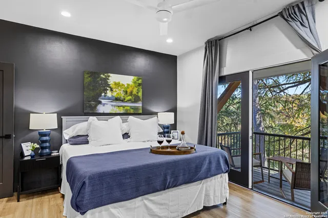 a bedroom with a large bed and a flat tv screen on dresser