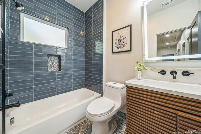 a white toilet sitting next to a bathroom sink and a bathtub