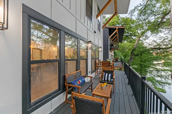a balcony with wooden floor and outdoor seating