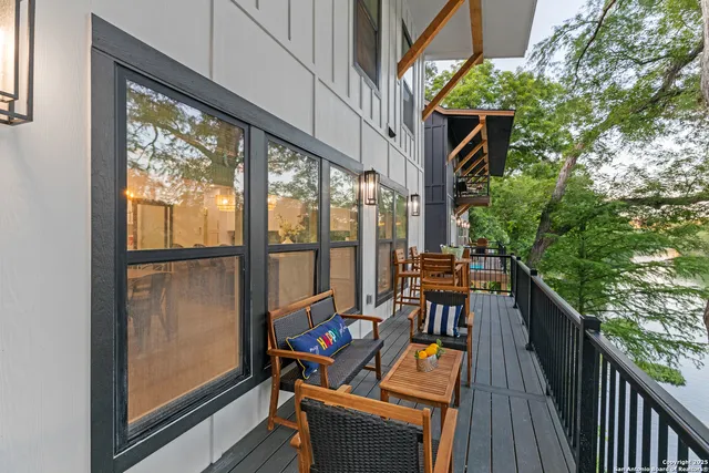 a balcony with wooden floor and outdoor seating