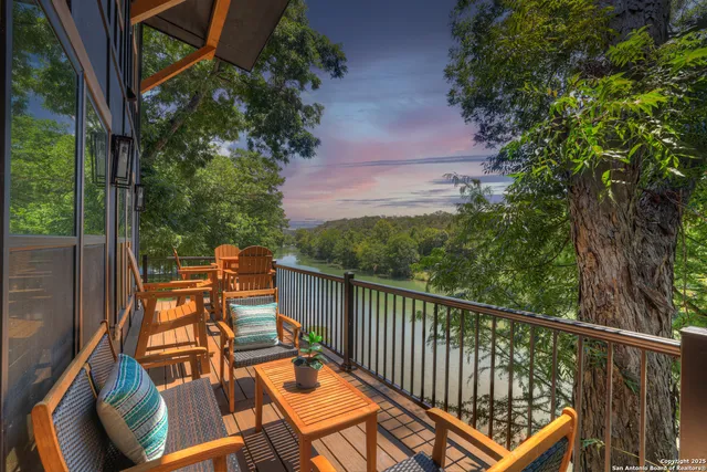 a balcony with wooden floor and outdoor seating