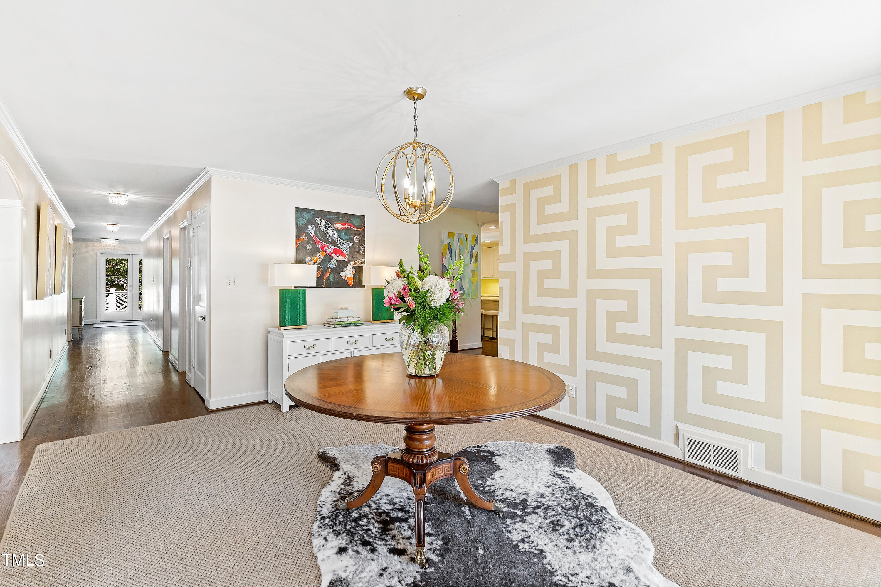 2618 Churchill Road Raleigh, NC 27608 - Photo 3 of 58 a dining room with wooden floor a chandelier a wooden table and chairs