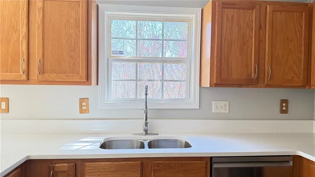 a view of an empty room with wooden floor fan and windows