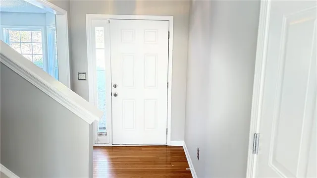 a view of a hallway with wooden floor and entryway