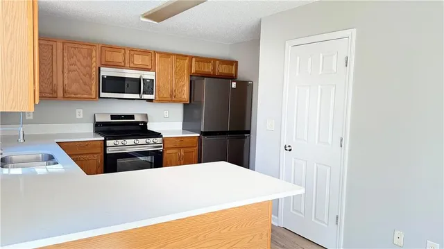 a kitchen with stainless steel appliances a refrigerator stove and microwave