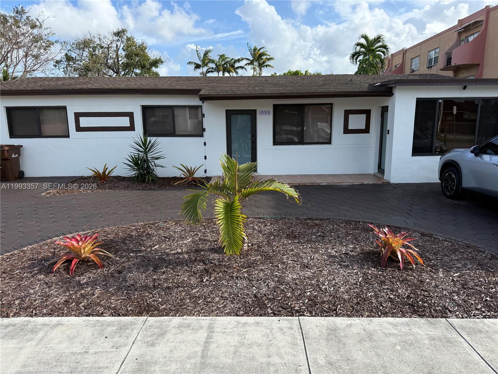 1050 West 37th Street Hialeah, FL 33012 - Photo 2 of 19 a backyard of a house with barbeque oven table and chairs