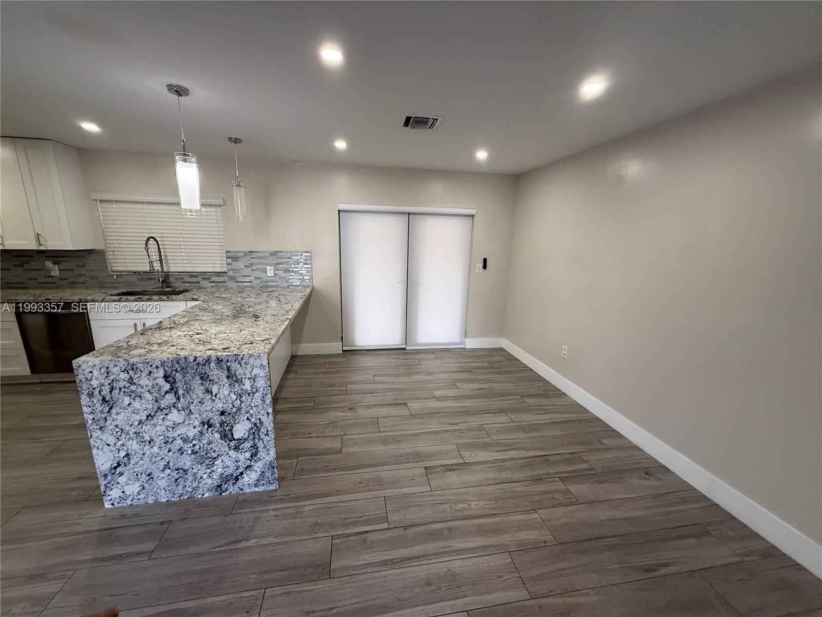 1050 West 37th Street Hialeah, FL 33012 - Photo 5 of 19 a view of kitchen and kitchen with granite countertop wooden floor