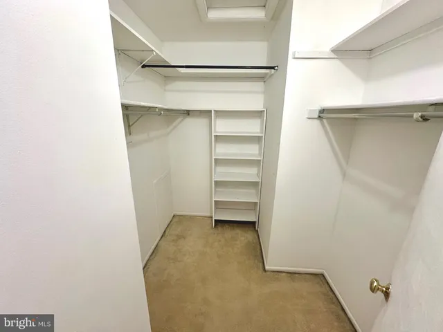 a view of walk in closet with empty racks