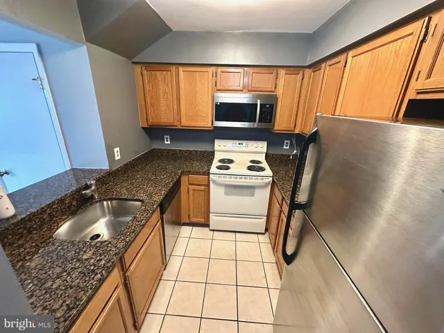 a kitchen with a sink a microwave a stove and refrigerator