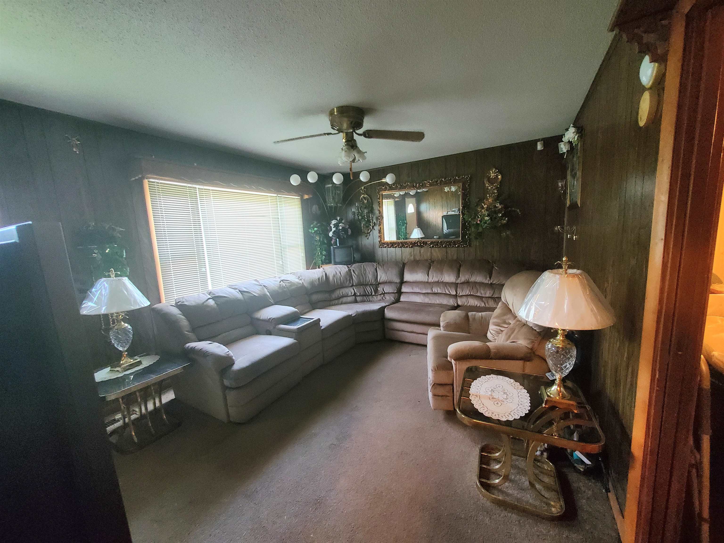 147 Rogers Street Sharon, TN 38255 - Photo 6 of 16 Living area featuring wood-paneled walls and a ceiling fan with integrated lighting