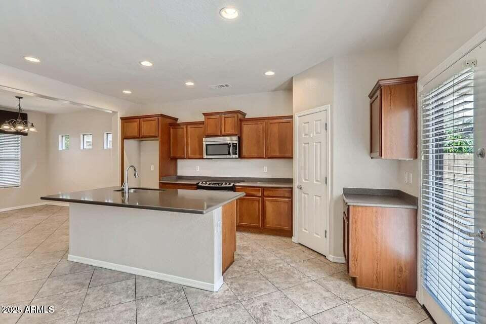 2039 West Kathleen Road Phoenix, AZ 85023 - Photo 10 of 33 a kitchen with stainless steel appliances granite countertop a stove a sink and a refrigerator
