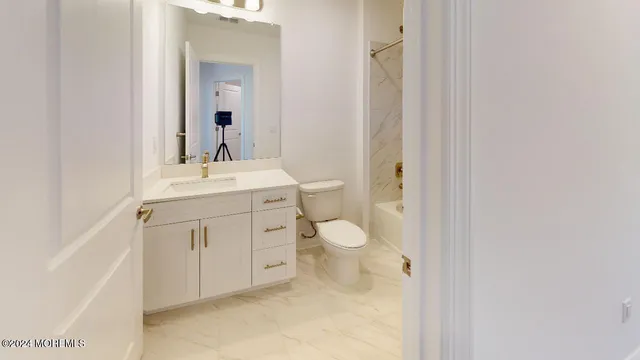 a spacious bathroom with a toilet sink and mirror