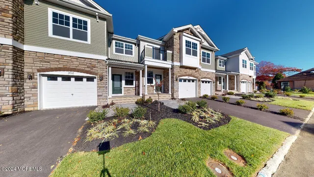 a view of a white house next to a yard with big trees