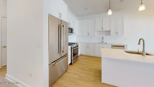 a kitchen with granite countertop a refrigerator and a sink