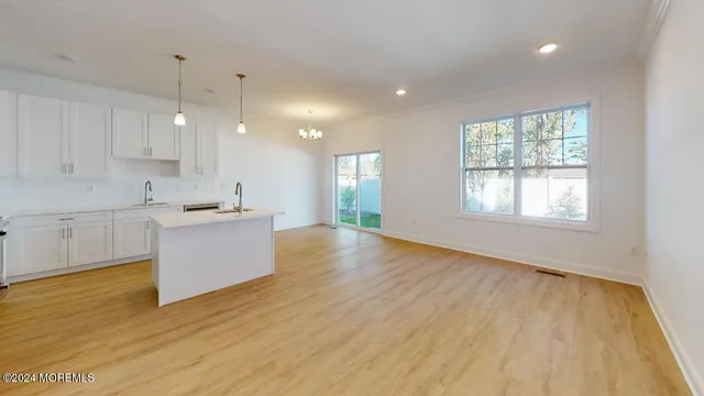 a view of a kitchen with kitchen island a sink wooden floor and a window
