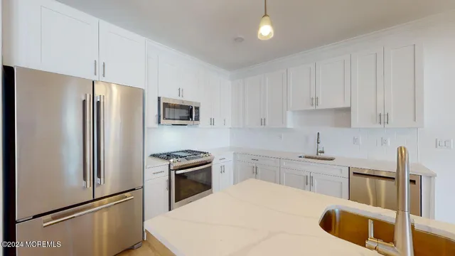 a kitchen with stainless steel appliances granite countertop a refrigerator sink and stove