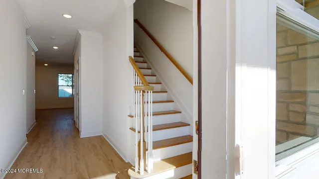 a view of a hallway with wooden floor and entryway