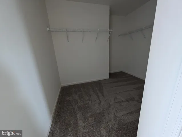 an empty room with wooden floor chandelier and windows