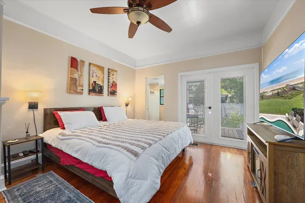 a spacious bedroom with a bed and wooden floor