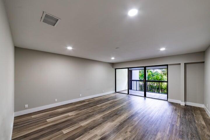2517 Presidential Way, Unit B West Palm Beach, FL 33401 - Photo 16 of 45 an empty room with wooden floor and windows
