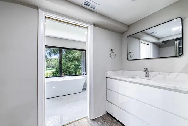 a bathroom with a granite countertop sink and a mirror
