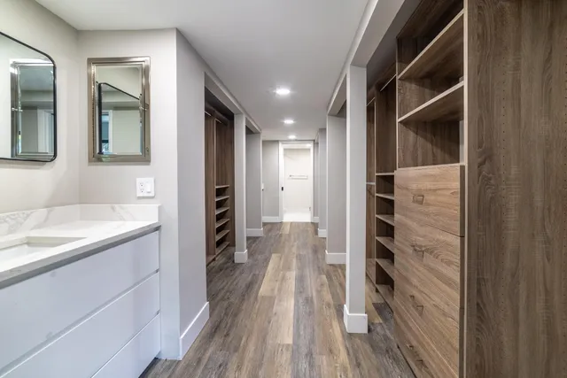 a bathroom with a walk in closet and wooden floor