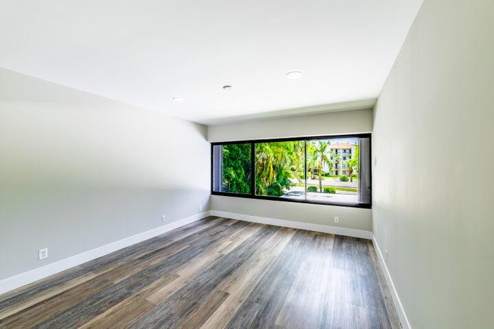 2517 Presidential Way, Unit B West Palm Beach, FL 33401 - Photo 28 of 45 an empty room with wooden floor and windows