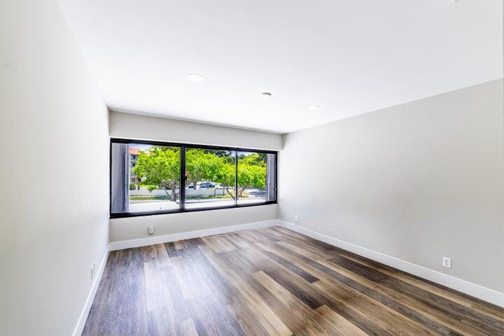 2517 Presidential Way, Unit B West Palm Beach, FL 33401 - Photo 32 of 45 an empty room with wooden floor and windows