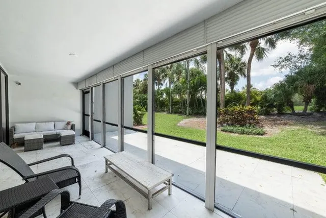 a living room with a floor to ceiling window chair and a table