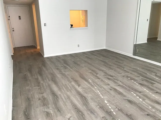 a view of empty room with wooden floor