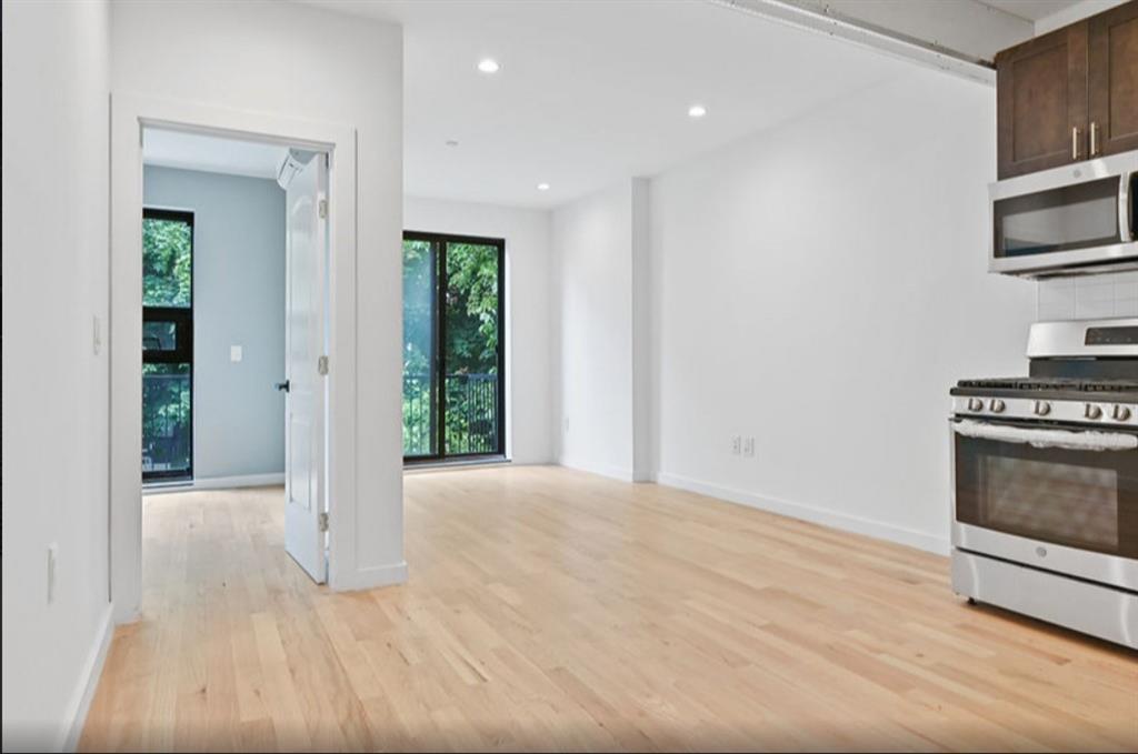 1115 Hancock Street Brooklyn, NY 11221 - Photo 24 of 33 a view of an empty room with a fireplace and a window